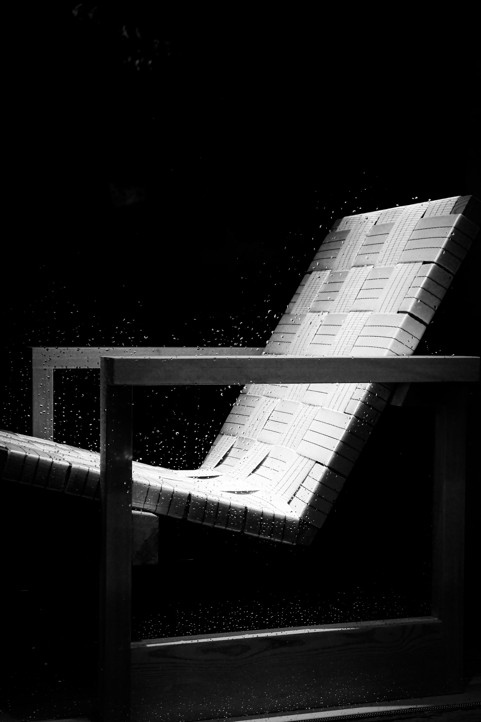 Lounge chair with a woven seat in a dark studio