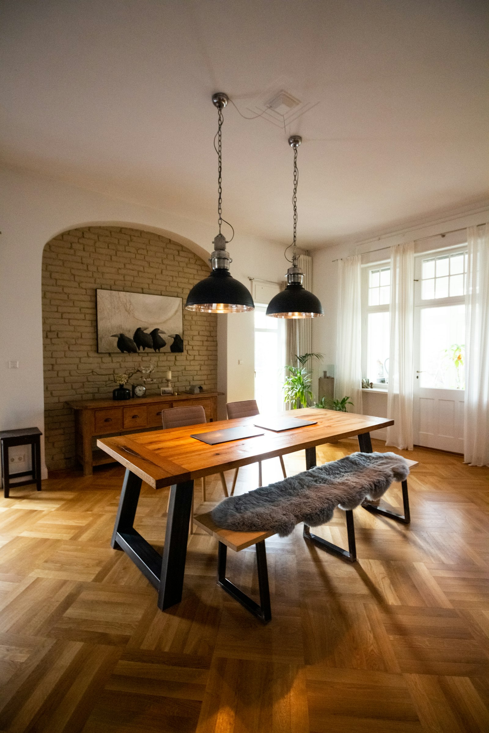 Long oak table with a bench under black pendants