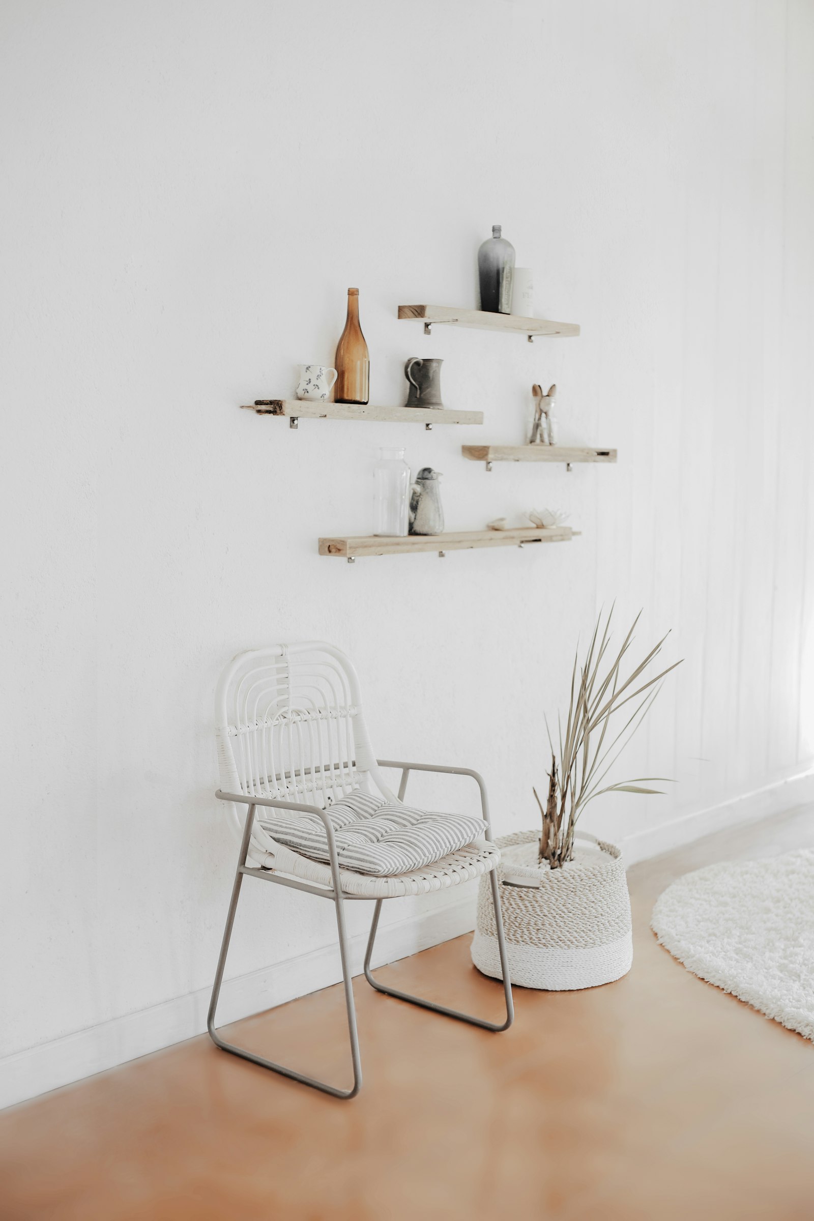 White wire chair beneath floating shelves