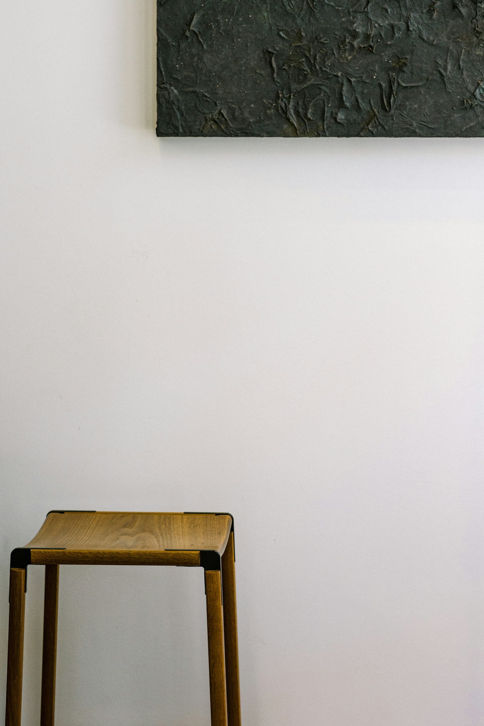 Low wooden bench against a white wall